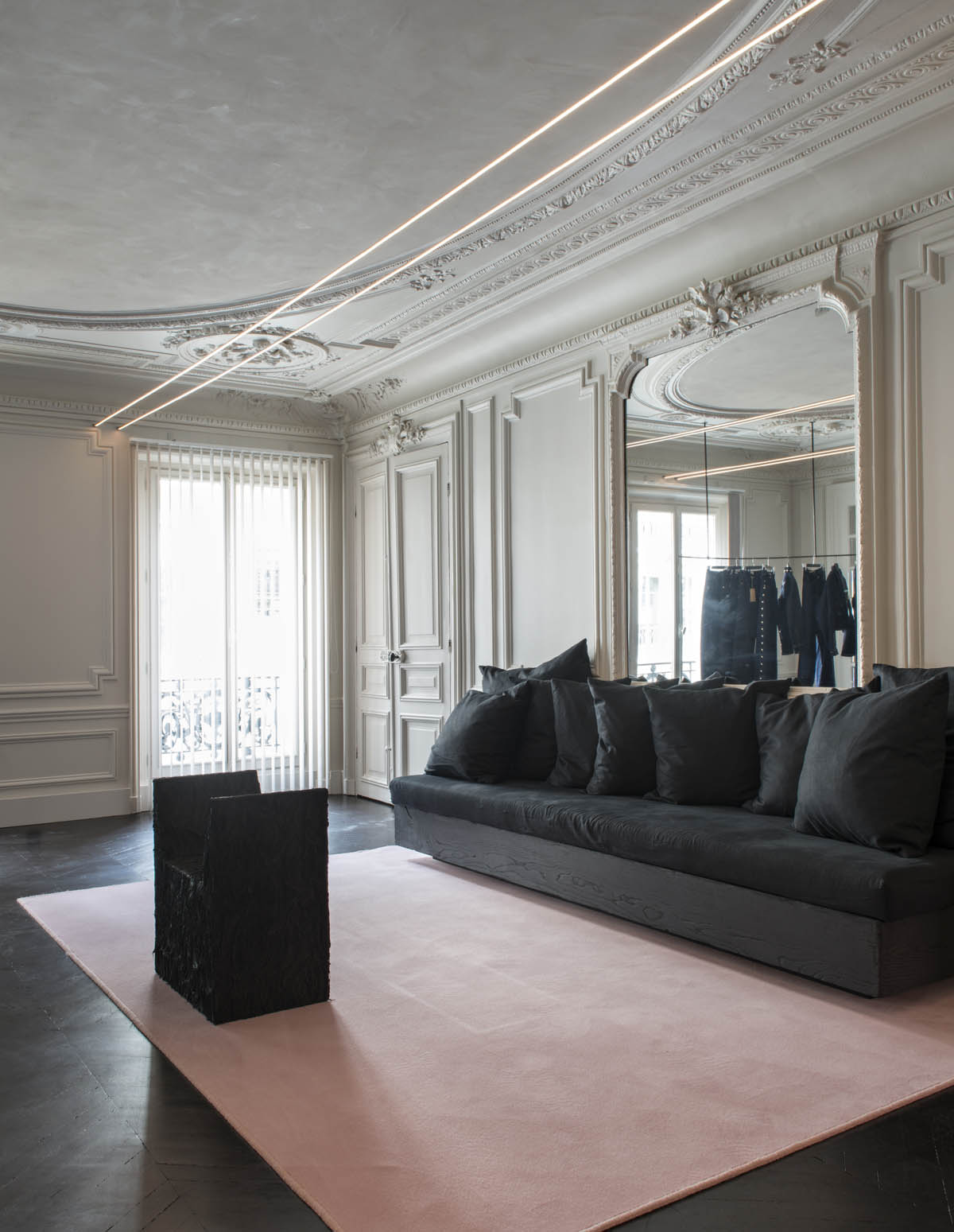 Black linen Sofa against a wall in haussmannian miror in the offices of Youssef Marquis agency