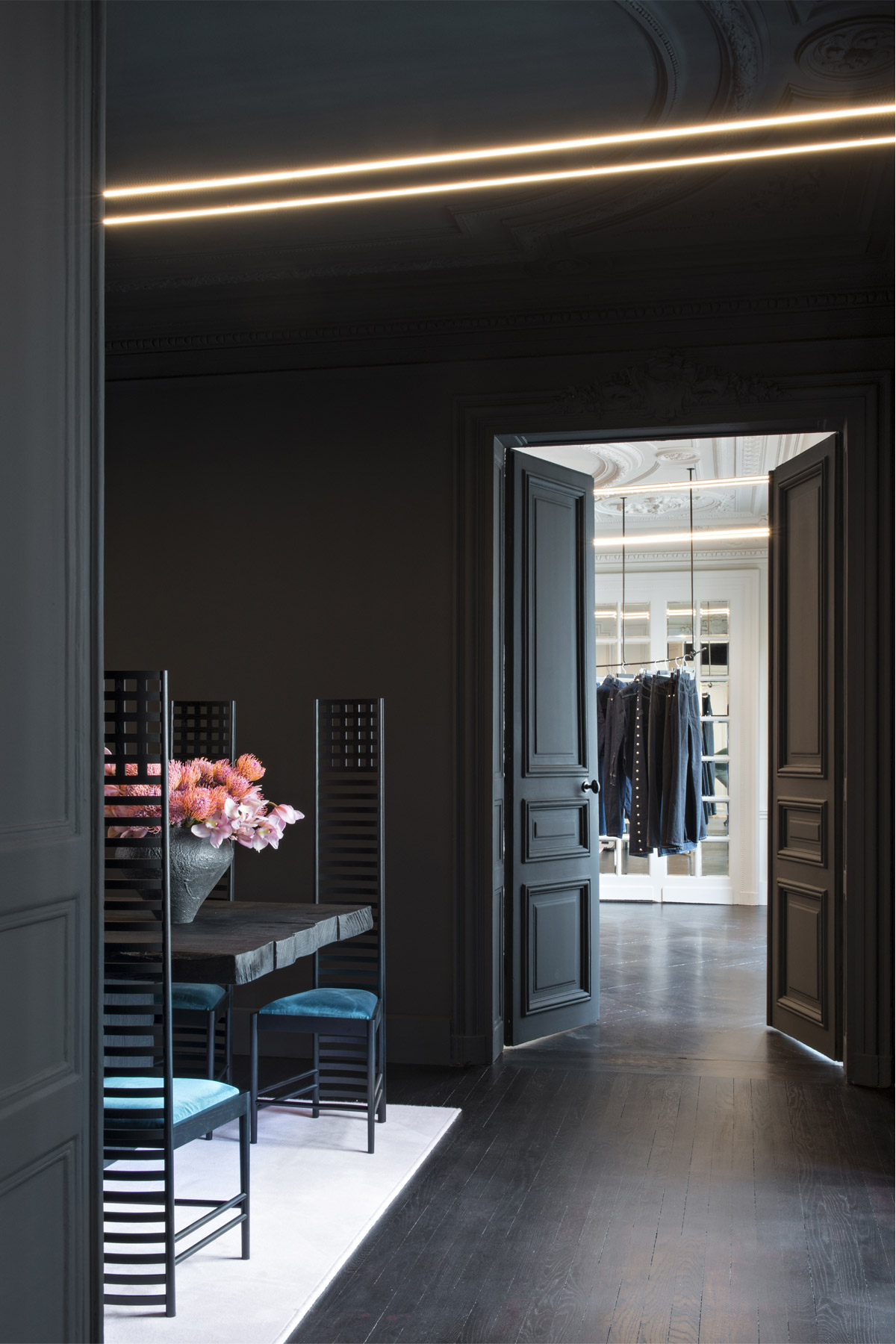 Perspective entre pièces noires et blanches dans un appartement haussmannien siège des bureaux de l'agence Youssef Marquis