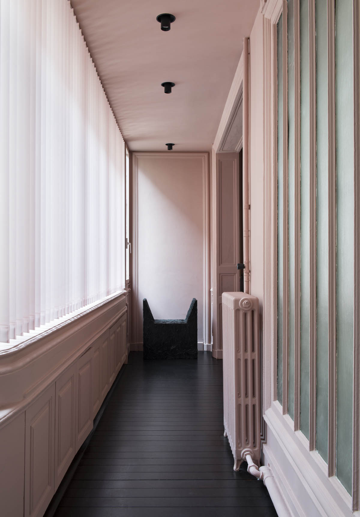 Arno Declercq chair at the end of corridor with pink curtain stores along windows in the offices of the Youssef Marquis agency