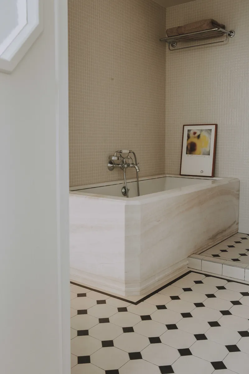 Salle de bain en marbre blanc avec baignoire sur mesure et sol Winckelmans.