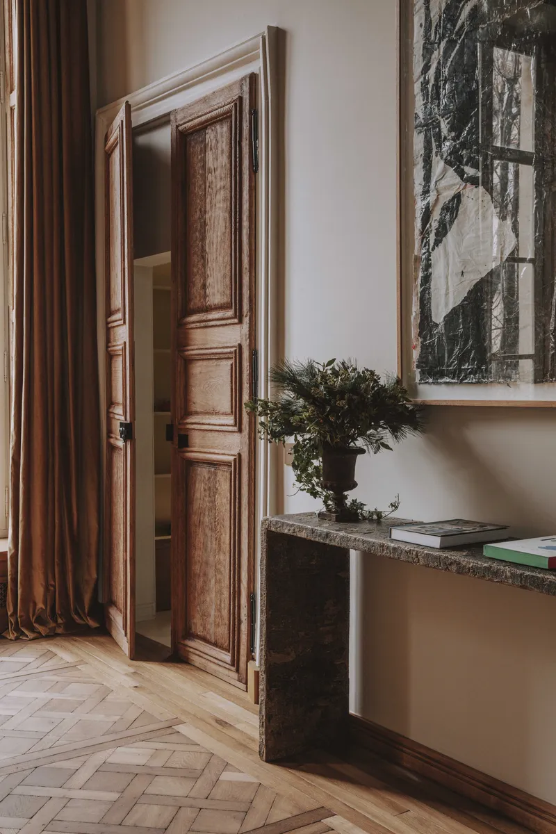 Double porte sablée ancienne avec rideaux Nobilis dans un intérieur wabi-sabi.