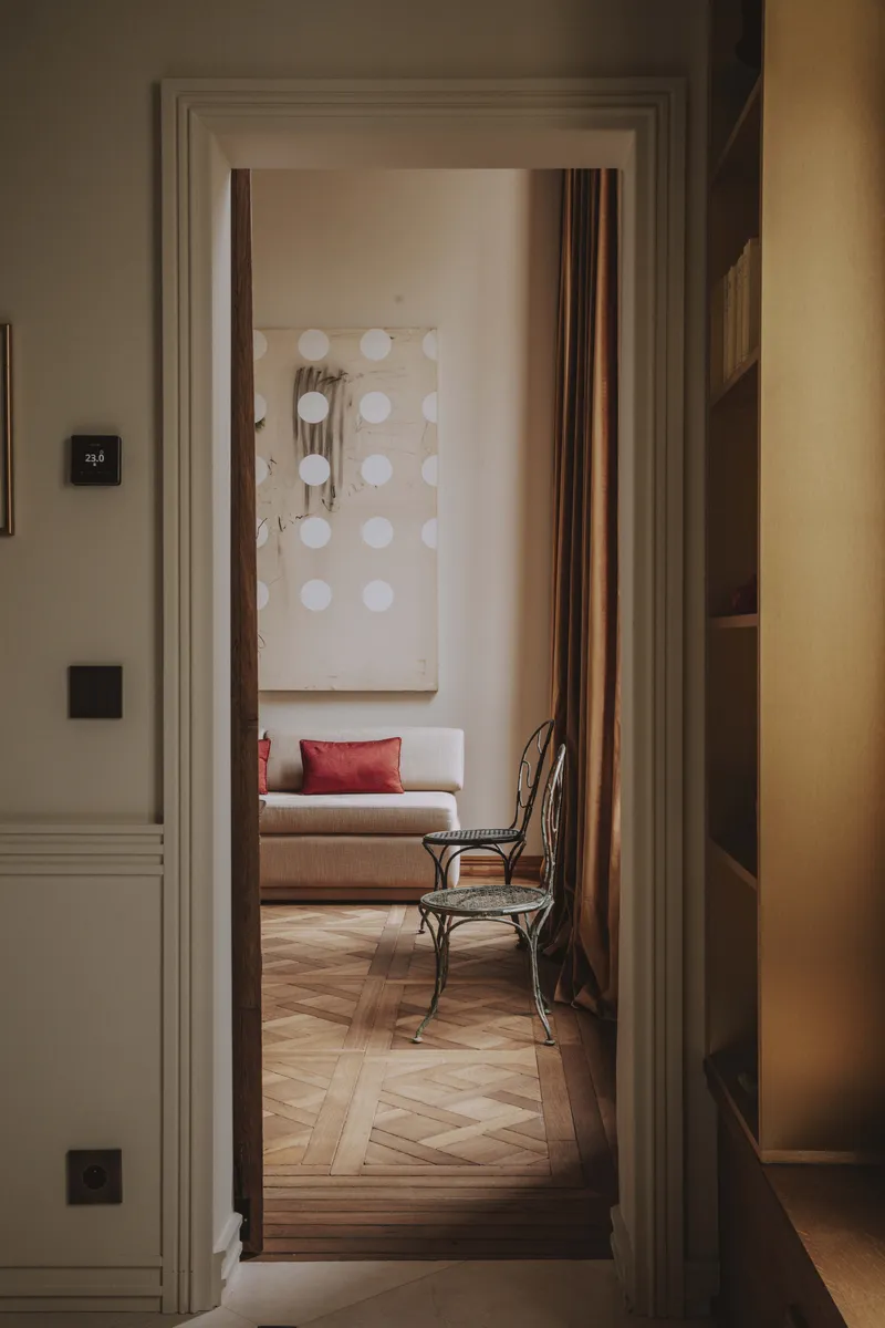 Couloir parisien avec moulures art déco sur mesure et œuvres d’art murales.