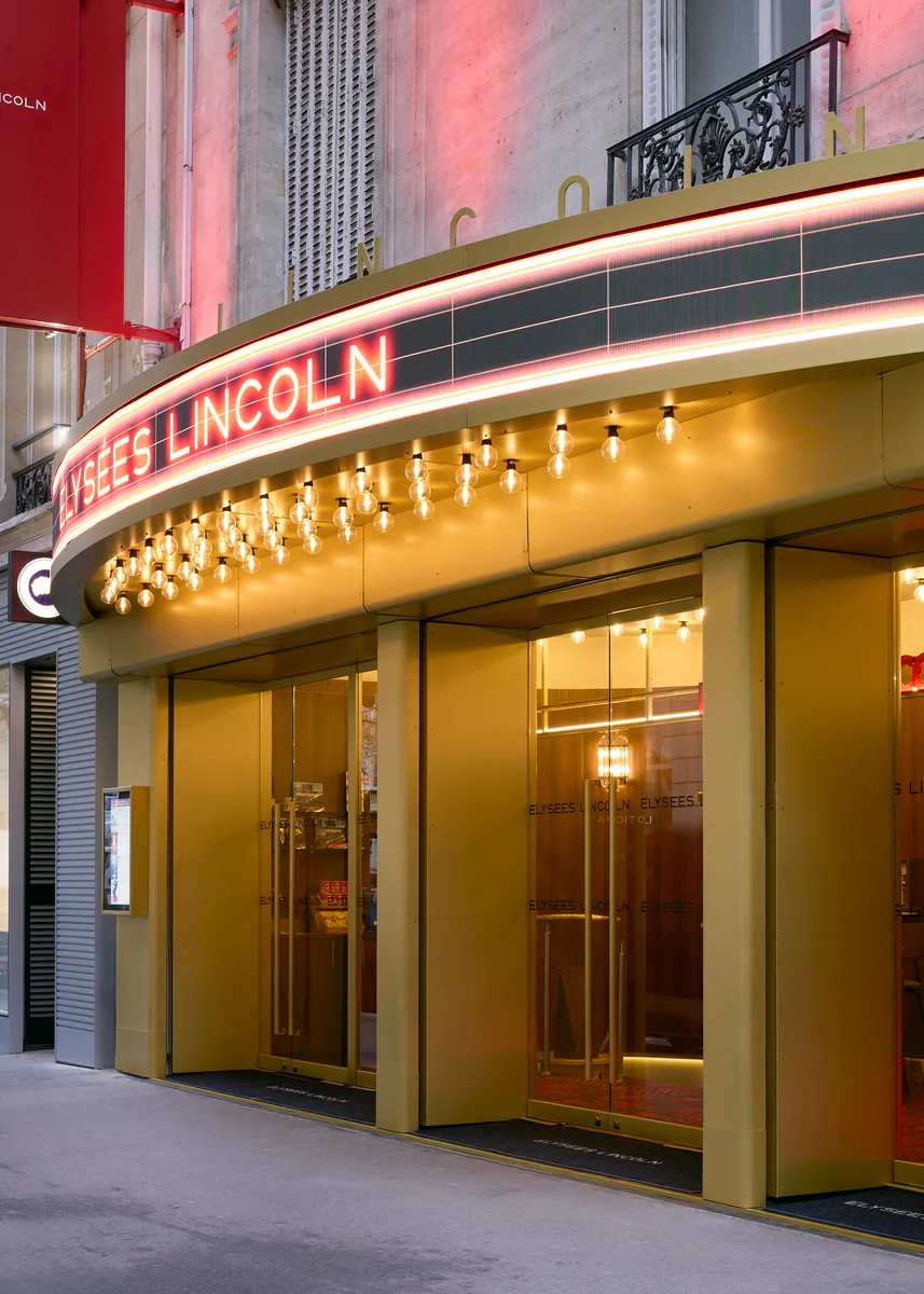 Cinema facade and illuminated marquee in Paris, with LED band, bare bulbs and brass cladding.