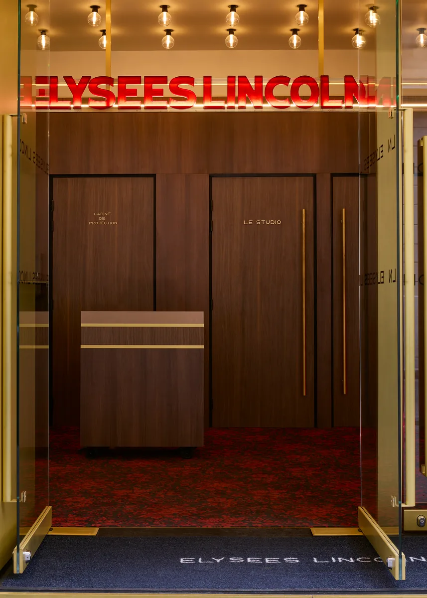 Cinema entrance with a bespoke neon sign, leading to the projection booth and Le Studio.