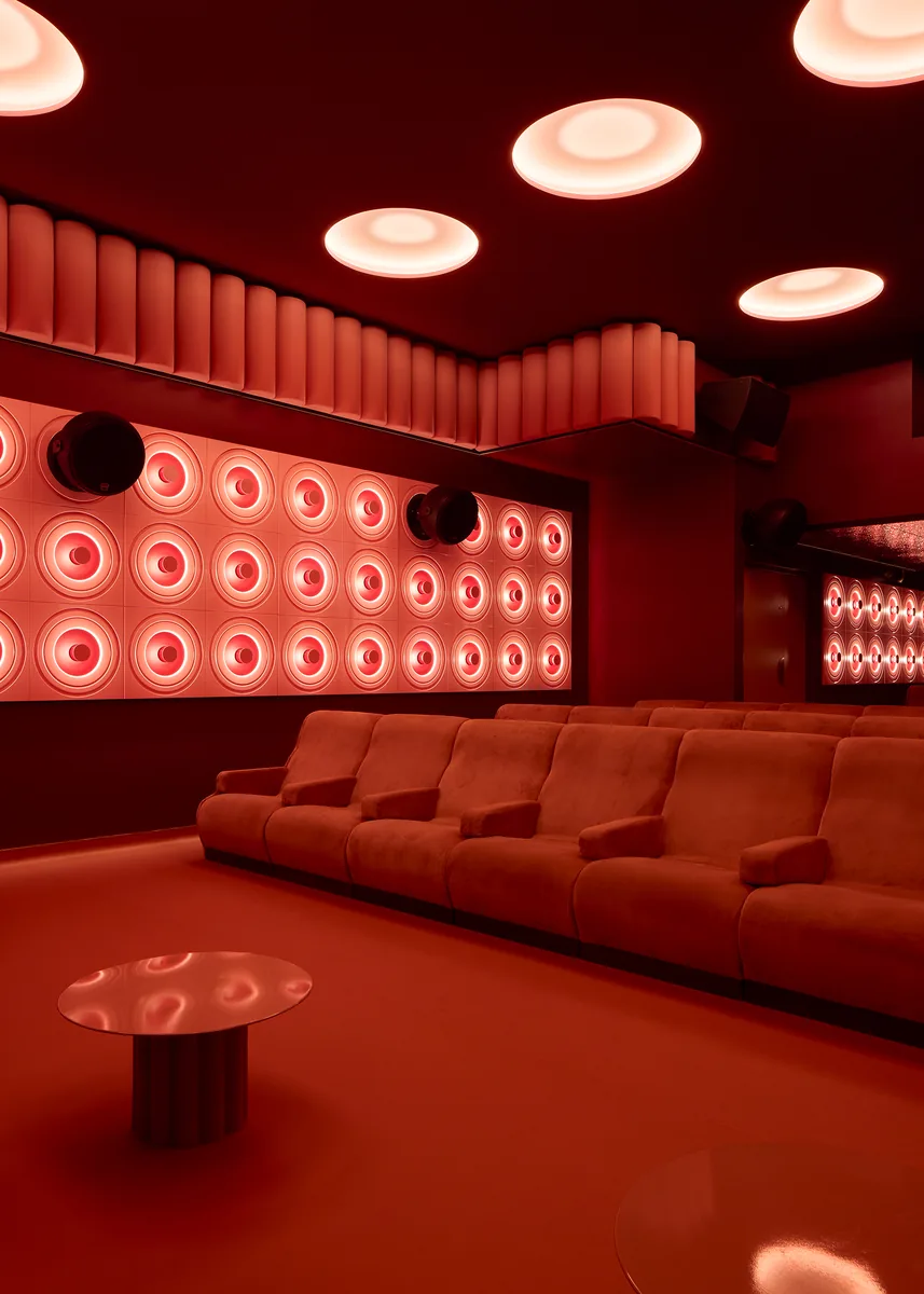 Le Club, a modular auditorium for private hire, with a backlit disc wall and fluted side tables.