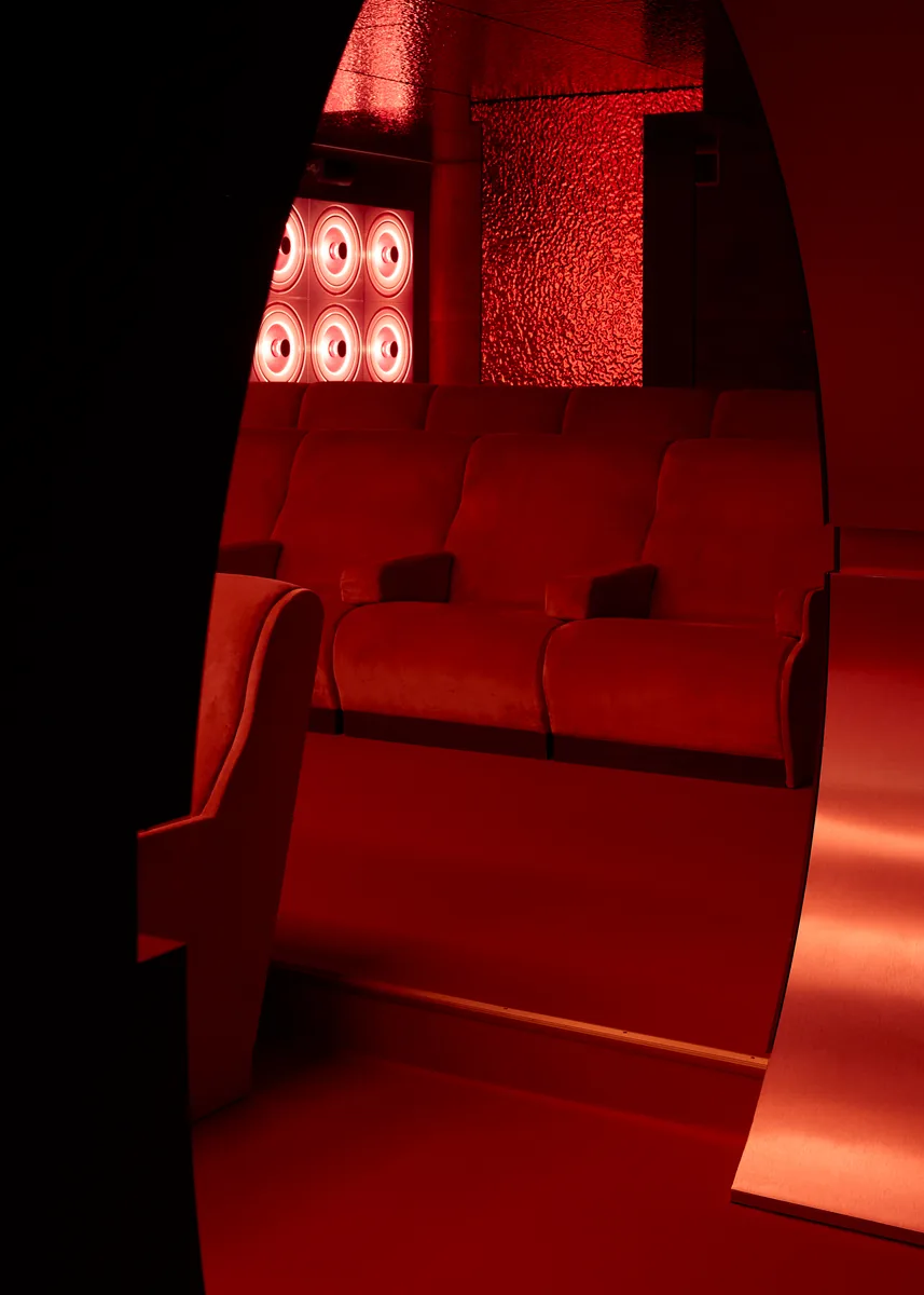 Le Club event auditorium seen through the arch, with brushed brass and red velvet.